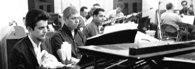 Don behind the piano during a session, second from left.
